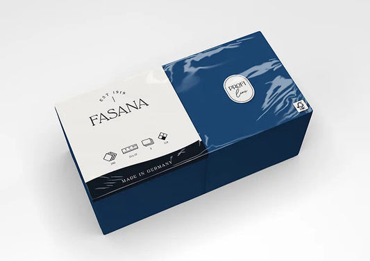 Auf dem Bild ist eine Verkaufsverpackung von Servietten der Marke FASANA in royal blue in 33x33cm und 1/4 Falzung von schräg oben zu sehen. Bild ©FASANA Verwendung mit freundlicher Genehmigung